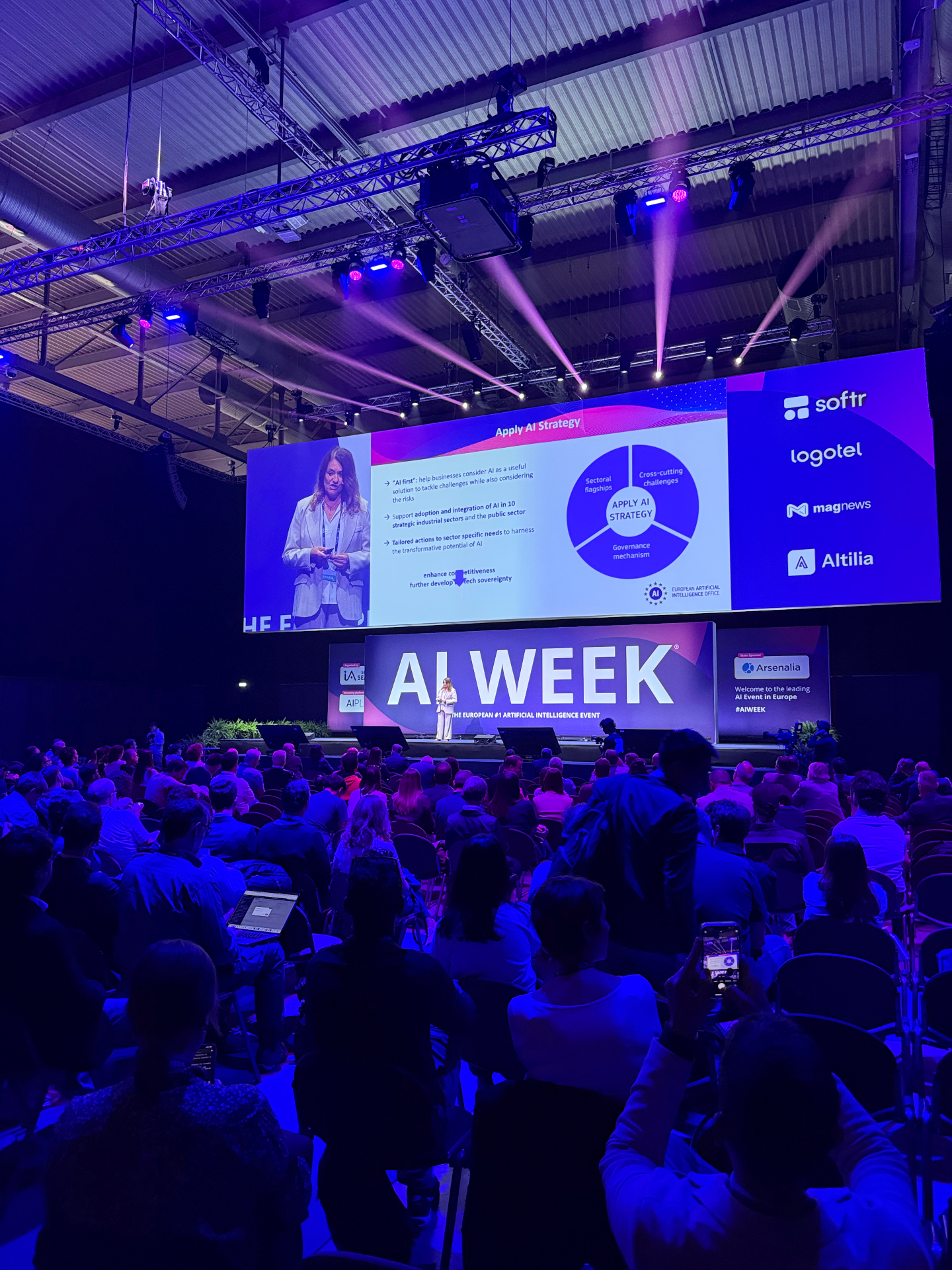 Palco principal da AI Week com plateia cheia durante keynote sobre Apply AI Strategy